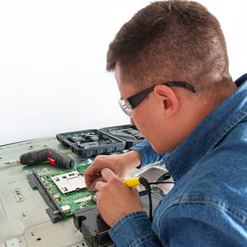 Tv repairman using a soldering iron to fix a circuit board from a modern television